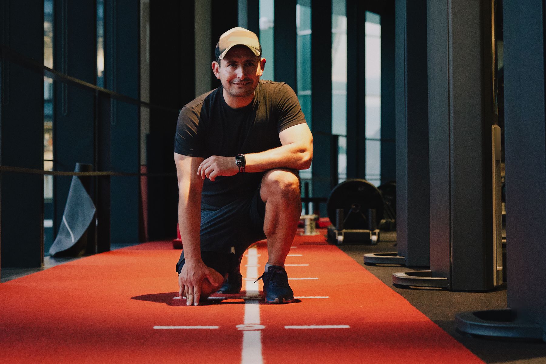 Roland Feizo kneeling on the sled track at Stars Gym, Battersea.