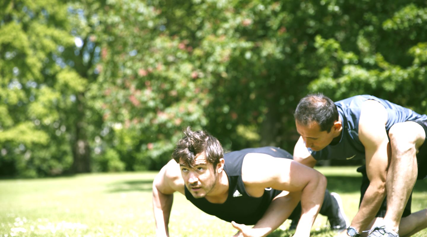 Roland coaching a client through a push-up.