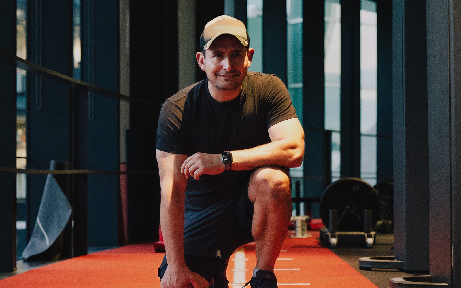 Roland Feizo kneeling on the sled track at Stars Gym, Battersea.
